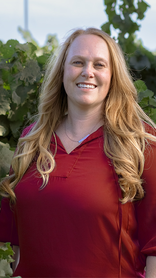 Winemaker Alison Crowe with her dog outside in a vineyard